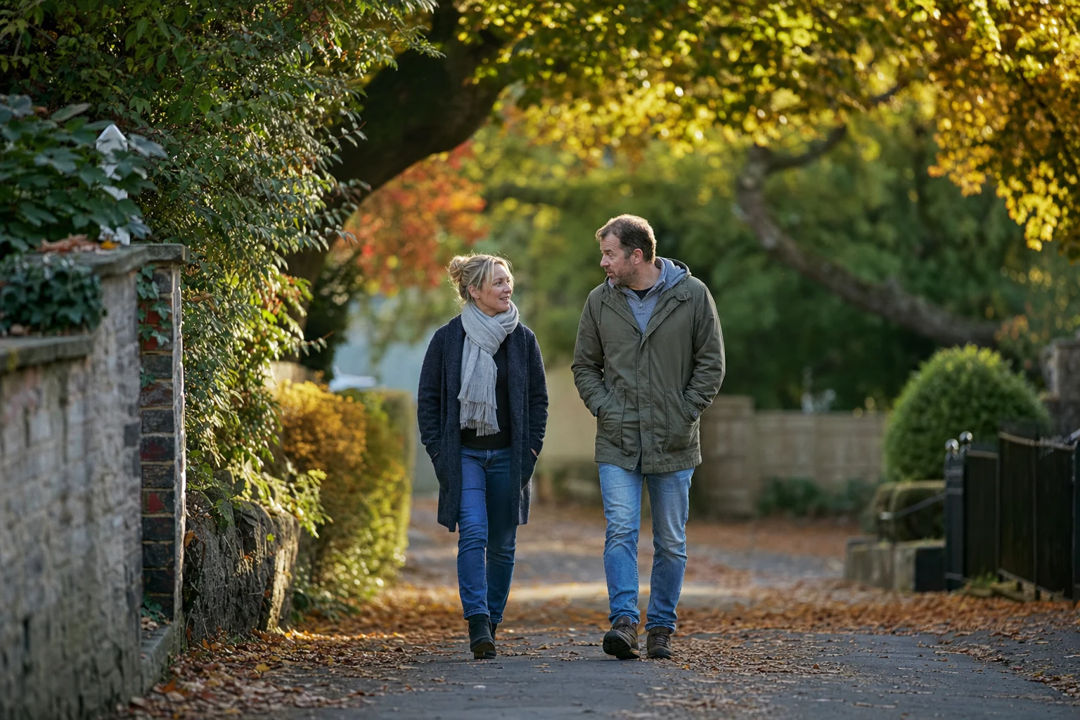 A couple walking side by side on an autumn path, talking